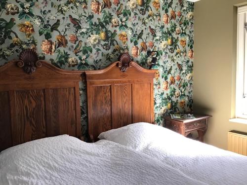 1 dormitorio con 1 cama y papel pintado con motivos florales en Rembrandthuis en Ommen