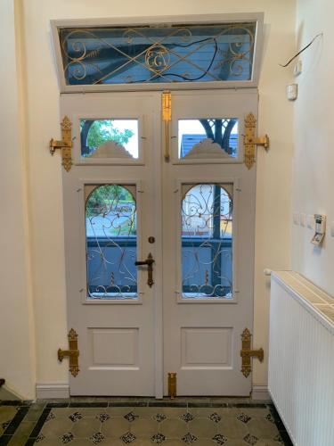 a white door with three windows in a room at Vila Bohemia Saxon Switzerland & SPA in Šluknov