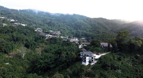 a village in the middle of a mountain with houses at Yamee Homestay Cafe in Ban Pha Mi