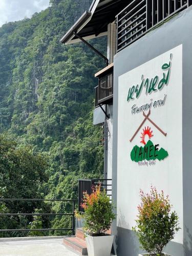 a sign on the side of a building with a mountain at Yamee Homestay Cafe in Ban Pha Mi