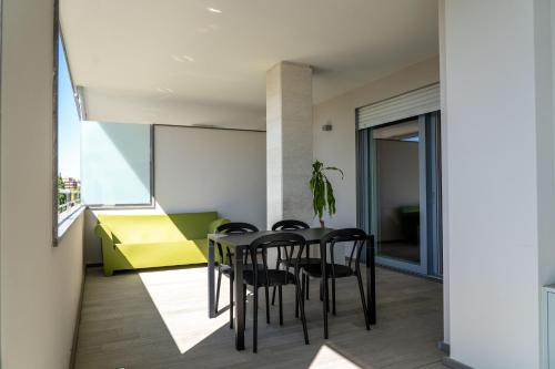 una sala da pranzo con tavolo, sedie e finestra di Bina Luxury Apartment a Cagliari
