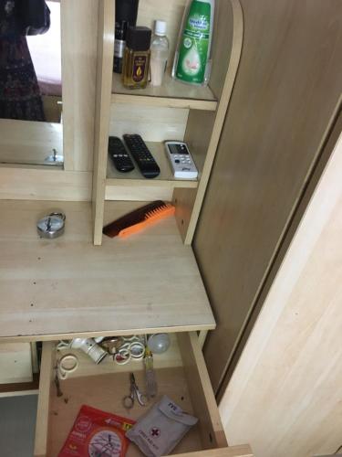 a room with a table and a shelf with tools at Lexus home in Ahmedabad