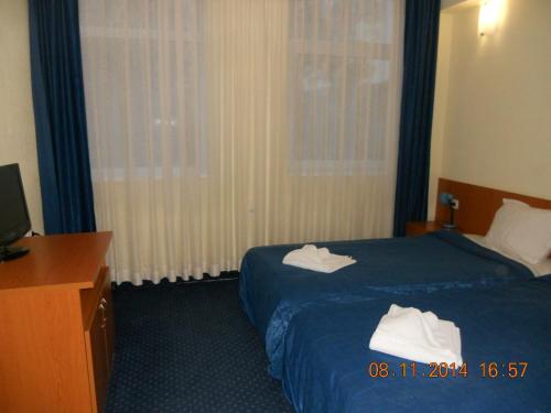 a hotel room with a bed with towels on it at Family Hotel Helios in Sevlievo