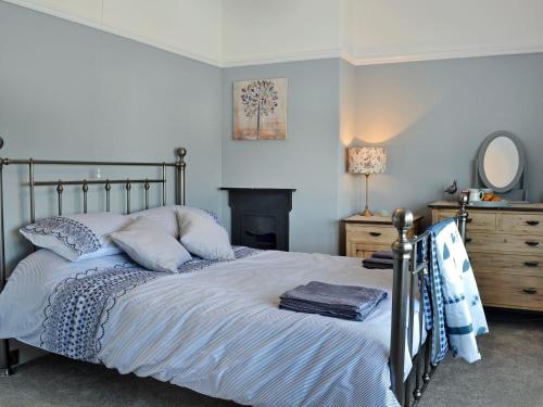 a bedroom with a bed and a dresser with a mirror at The Beach House in Saint Annes on the Sea