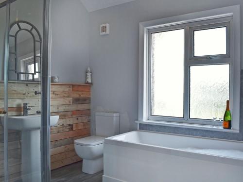 a bathroom with a tub and a toilet and a sink at The Beach House in Saint Annes on the Sea