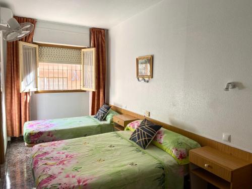 a hotel room with two beds and a window at Hotel Arce in San Pedro del Pinatar