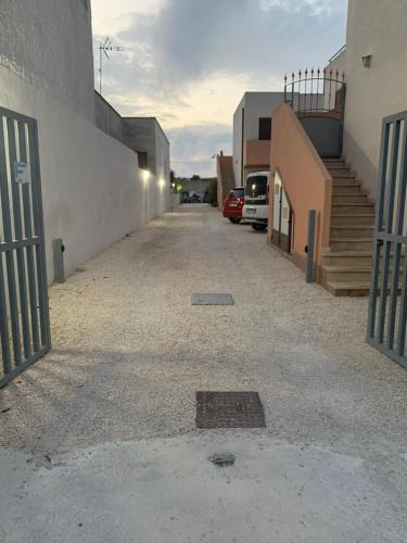 an alley with a gate and a car parked next to a building at Kite Village Solaris in Birgi Vecchi