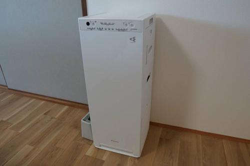 a small white refrigerator sitting next to a wall at ゆったりとした時間を過ごせる一棟貸切の別荘　たけしま in Naruto
