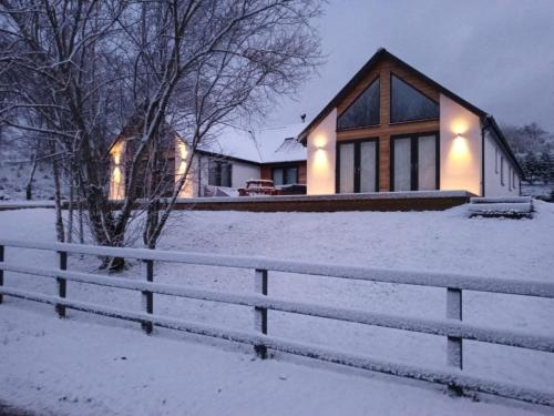 a house with a fence in the snow at Ben Nevis Scotland Highlands, Camden House luxury home in Fort William