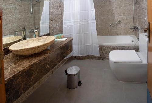 Sea Shore Hotel Apartment Khorfakkan في خور فكان: حمام مع حوض وحوض استحمام ومرحاض
