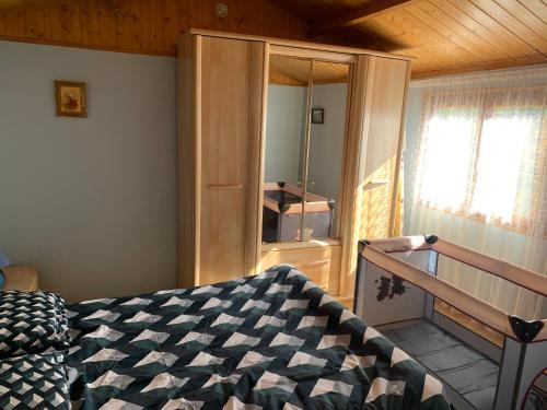 a bedroom with a bed and a staircase with a window at Le Petit Logis entre Auvers et Paris in Montigny-lès-Cormeilles