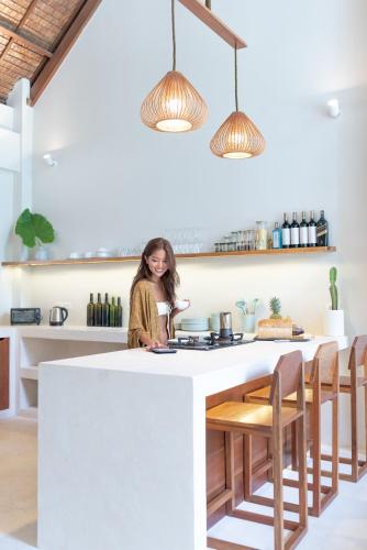 a woman sitting at a kitchen island in a room at SEACLUB Siargao in General Luna