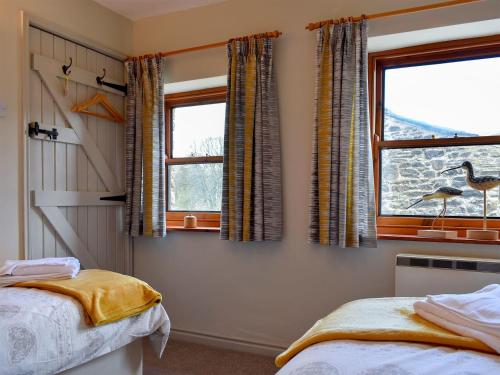 a bedroom with two beds and a window at 2 Swallowholm Cottages in Richmond