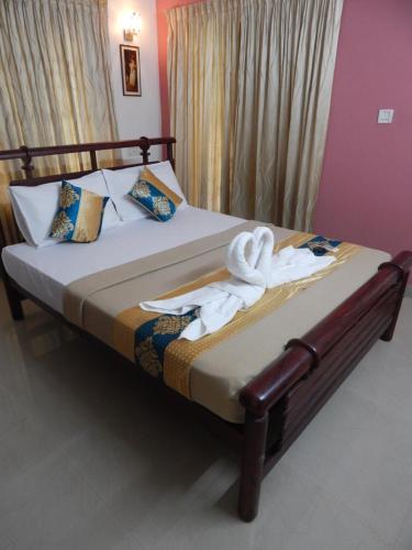 a bedroom with a bed with towels on it at Royal Homes in Kakkanad