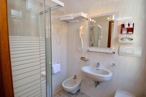 a bathroom with a sink and a toilet and a mirror at Hotel Orion in Venice