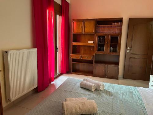 um quarto com cortinas cor-de-rosa e duas toalhas numa cama em Family Comfortable Spacious Apartment em Heraclião