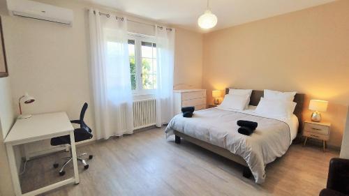 - une chambre avec un lit et un bureau dans l'établissement VILLA REVE D'OCEAN climatisée, à Gujan-Mestras