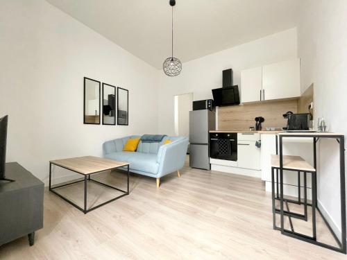 uma sala de estar com um sofá azul e uma cozinha em Bleu persan - SENS centre - Netflix em Sens