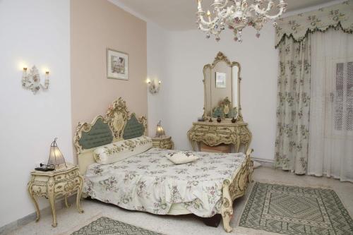 a bedroom with a bed and a mirror and a chandelier at Dar Henani in Monastir