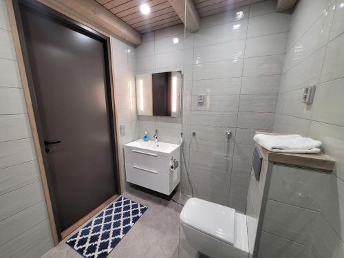uma casa de banho branca com um WC e um lavatório em Naava Chalet Loft 303 em Ähtäri