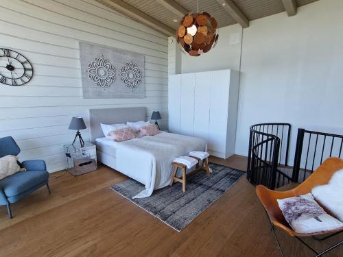 um quarto com uma cama, uma cadeira e um relógio em Naava Chalet Loft 303 em Ähtäri