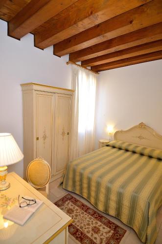 a bedroom with a bed and a table with a lamp at Hotel Orion in Venice
