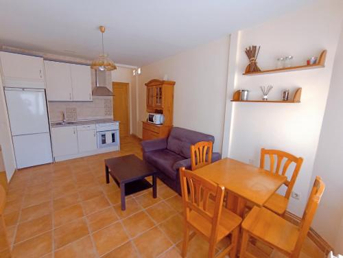 eine Küche und ein Wohnzimmer mit einem Tisch und einem Sofa in der Unterkunft El Rincón del Sanabrés, Hermana Menor, petfriendly in Rascafría