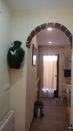 a hallway with a green vase on the wall at Apts la cañada birding con encanto y patio en monfrague torrejon el Rubio in Torrejón el Rubio
