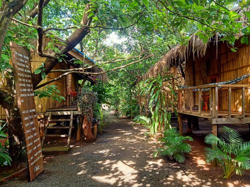 um caminho que leva a uma casa numa floresta em Tribal Village Homestay & Trekking em Banlung