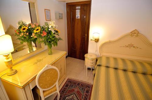 a bedroom with a bed and a desk with a mirror at Hotel Orion in Venice