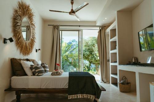 ein Schlafzimmer mit einem Bett und einem großen Fenster in der Unterkunft Kuwa Zanzibar in Kiwengwa