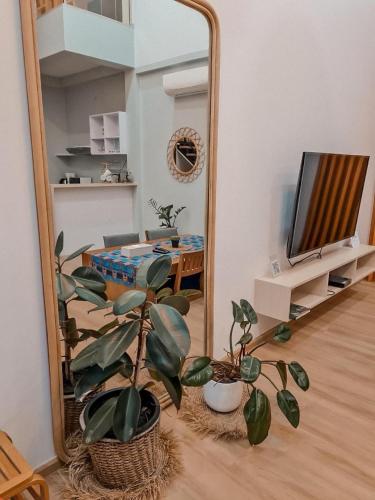 a mirror in a living room with a potted plant at Wayla Villa@Maikhaobeach in Mai Khao Beach