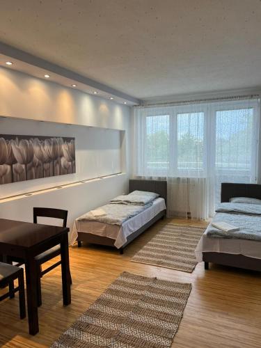 sypialnia z 2 łóżkami, stołem i krzesłami w obiekcie Komfortowe mieszkanie dla 4 osób w Siedlcach