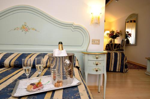 a hotel room with a bottle of champagne on a bed at Hotel Orion in Venice