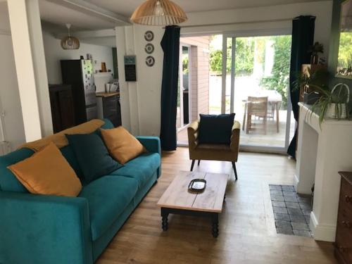 a living room with a blue couch and a coffee table at Niarnia in Abbeville