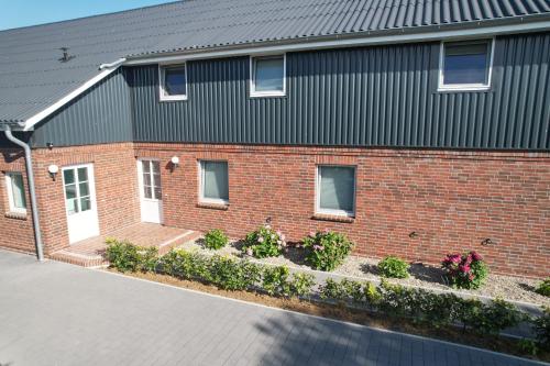 ニービュルにあるUrlaubswindの赤レンガ造りの黒屋根