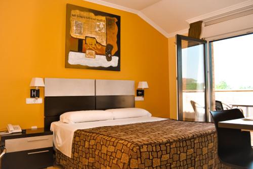 1 dormitorio con cama, escritorio y ventana en Hotel Reigosa en Pontevedra