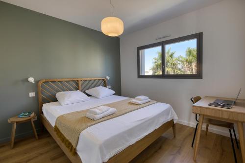 une chambre avec un lit, un bureau et une fenêtre dans l'établissement SOUTH-OF-FRANCE Magnifique T5 avec CLIM, terrasse 30 m2 vue sur mer et barbecue, parking, 40m de la plage, à Carnon-Plage