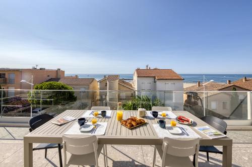 - une table avec de la nourriture sur le balcon donnant sur l'océan dans l'établissement SOUTH-OF-FRANCE Magnifique T5 avec CLIM, terrasse 30 m2 vue sur mer et barbecue, parking, 40m de la plage, à Carnon-Plage