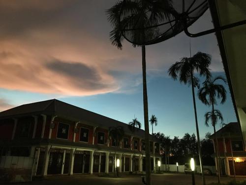 un edificio con palmeras delante en The nearest Surattani airport en Surat Thani