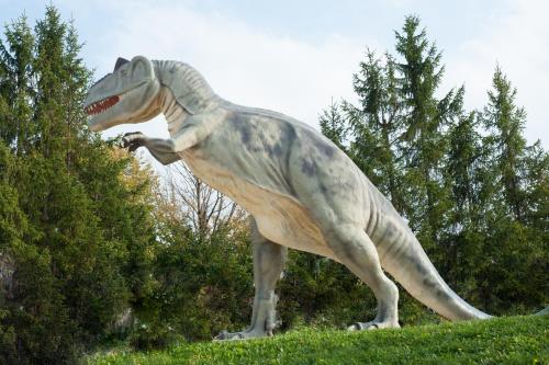 a statue of a dinosaur standing in the grass at Senefelder Hof in Solnhofen