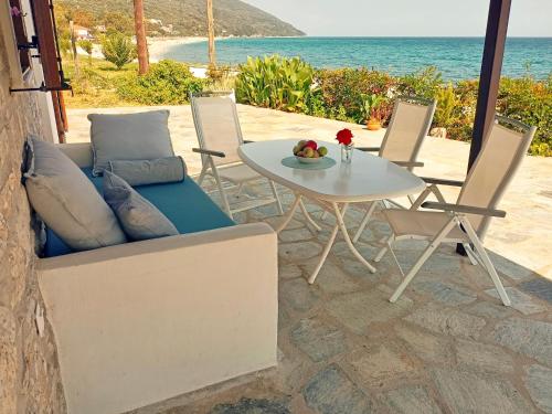 eine Couch und ein Tisch und Stühle auf einer Terrasse in der Unterkunft Seaside Villa Eleni in Khorevtón