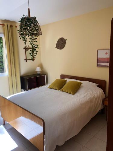 - une chambre avec un lit et une plante sur le mur dans l'établissement Maison Le Bel Air à 3km du virage de Mulsanne 9 couchages, à Ruaudin