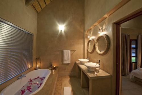 a large bathroom with a tub and two sinks at Emanya@Etosha in Namutoni