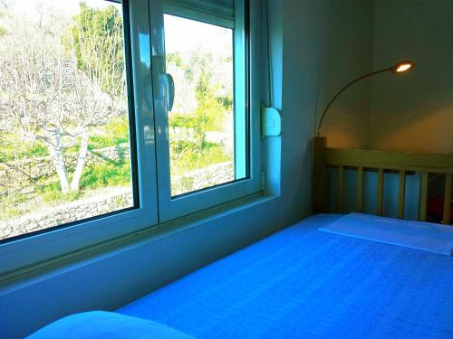 a bedroom with a blue bed and a window at Hoxha rooms in Ulcinj