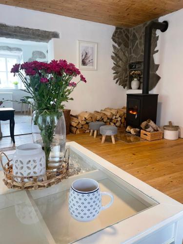 a kitchen with a vase of flowers and a fireplace at Romantická chalupa s krbem in Hořice na Šumavě