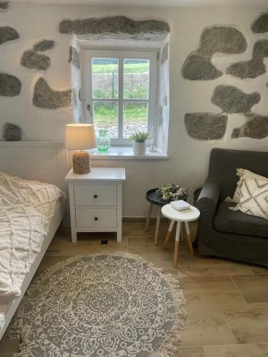 a living room with a couch and a window at Romantická chalupa s krbem in Hořice na Šumavě