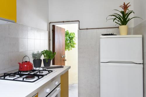 a kitchen with a stove and a white refrigerator at La Gabbia del Grillo in Florence