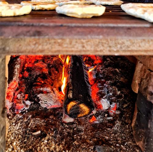 a pizza oven with a fire in it at Pensiunea Agroturistica Casa Brazilor in Sărişoru Mare