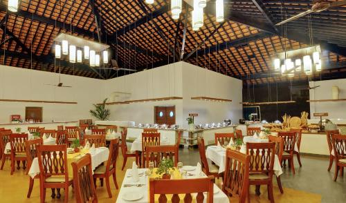 a dining room with tables and chairs in a room at Novotel Goa Dona Sylvia Resort in Cavelossim